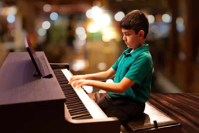 Young boy playing piano at performance